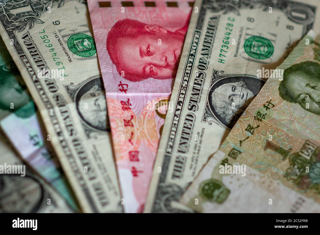 Konzept des US-China-Handelskrieges. Chinesische Renminbi (Yuan) Geldscheine mit grünen US-Dollar-Noten. Zeigt Handel, Handel, Importe, Exporte. Stockfoto