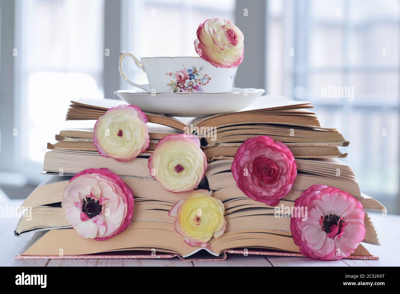 Tasse Tee auf einem Stapel Bücher und Blumen Stockfoto