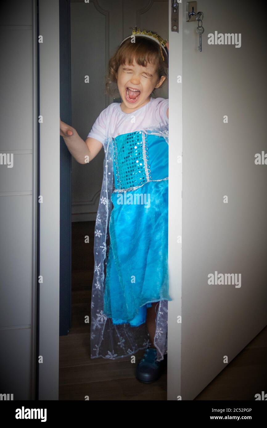 Portrait eines Mädchens, das als Prinzessin gekleidet ist und eine Tür öffnet Stockfoto