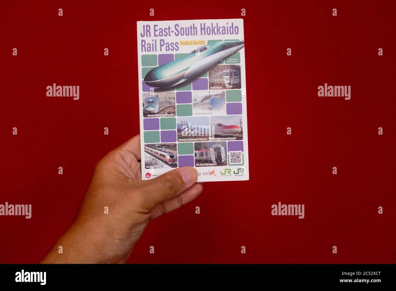 Penang, Malaysia - 25. Mai 2020 : Nahaufnahme einer Hand, die einen gebrauchten JR East South Hokkaido Rail Pass auf weißem Hintergrund bei Gelugor hält Stockfoto