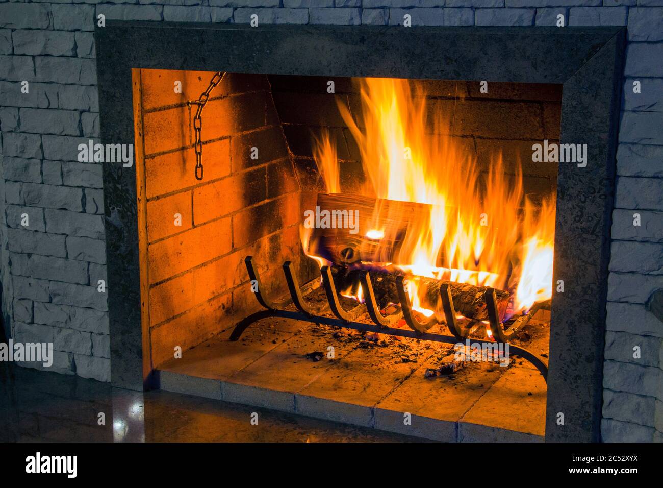 Brennendes Brennholz in einem Kamin, helle Flammen, ein Symbol für Wärme und Komfort im Haus Stockfoto
