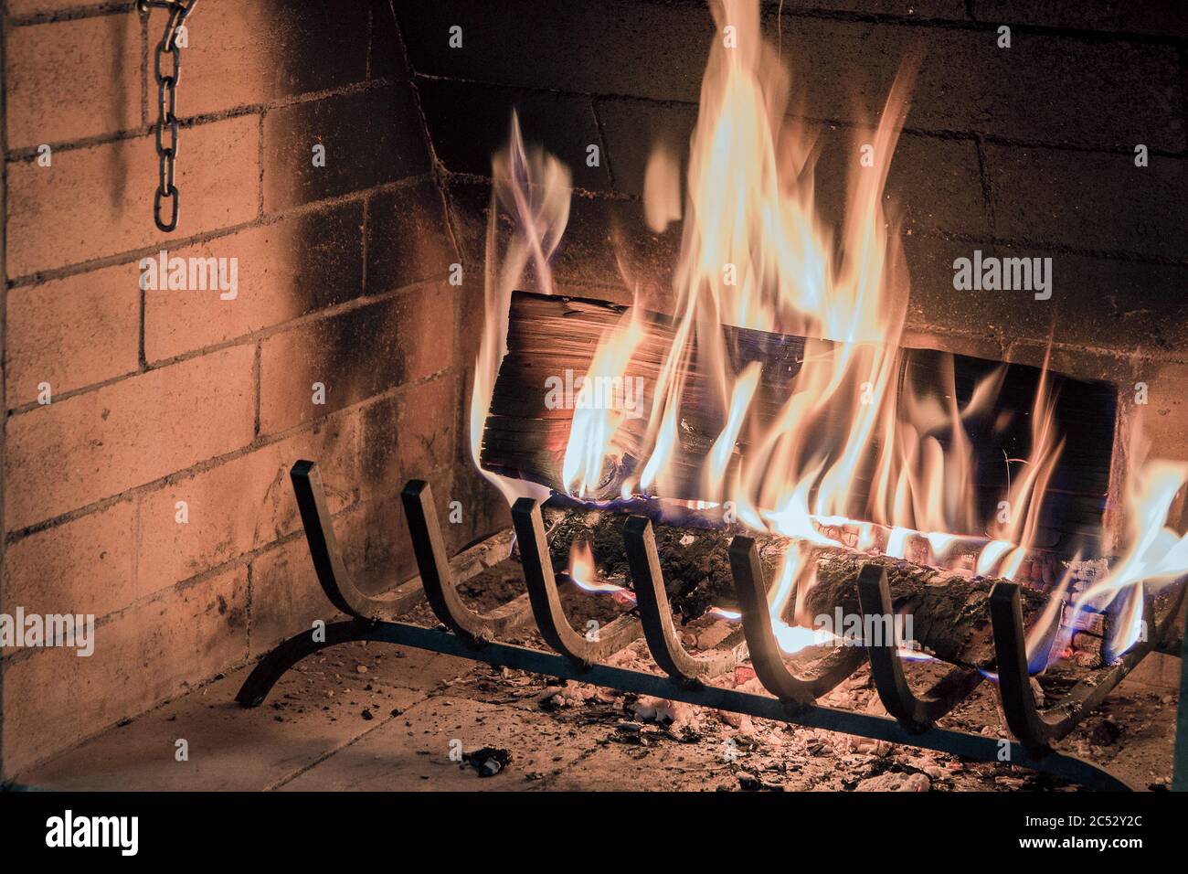 Brennendes Brennholz in einem Kamin, helle Flammen, ein Symbol für Wärme und Komfort im Haus Stockfoto