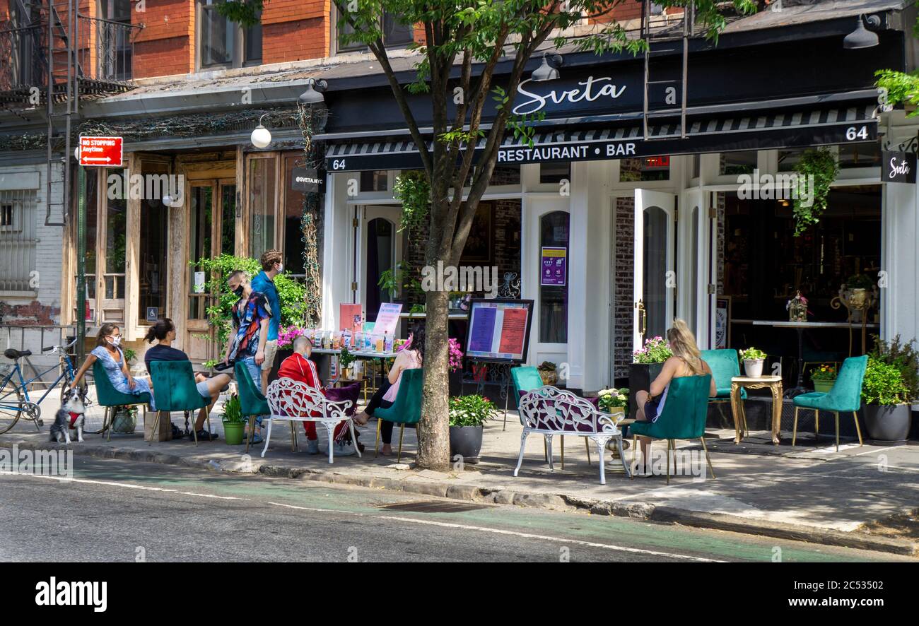 Menschen essen und trinken auf dem Bürgersteig vor dem Restaurant, New York City, New York, USA Stockfoto