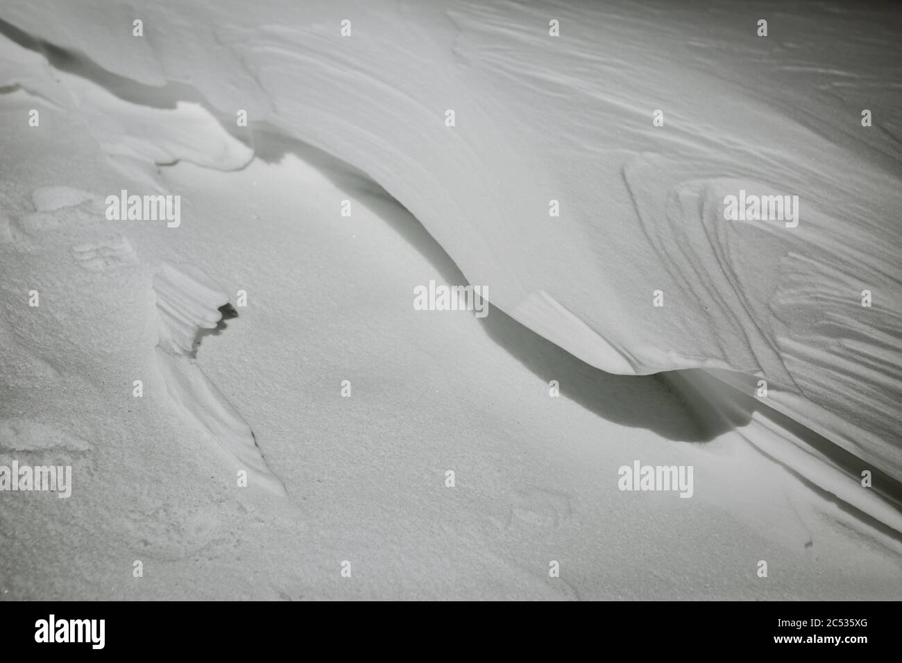 Schöne minimalistische Detail der Form von gefrorenen Stück Schnee durch Wind mit schönen schneebedeckten Textur aus der niedrigen Winkel-Ansicht gemacht Stockfoto