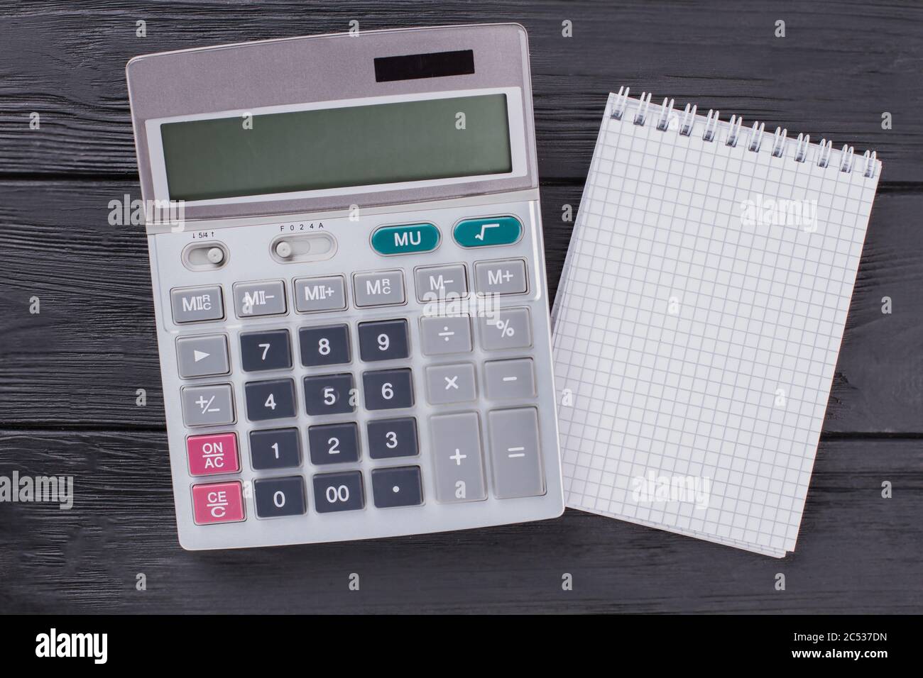 Rechner und Notizblock auf dunklem Holztisch. Stockfoto