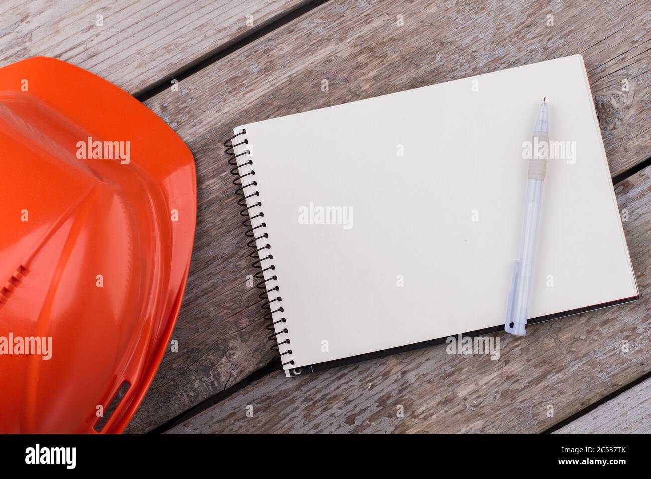 Leerer Notizblock mit Stift und Helm. Stockfoto