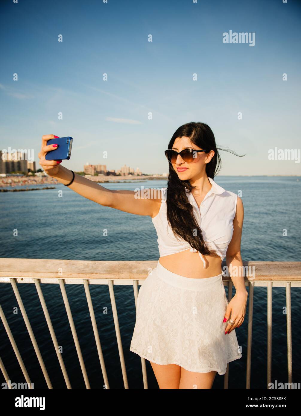 Junge Frau, die ein Selfie am Strand Stockfoto
