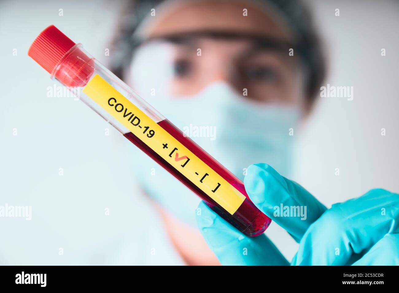 Laborfrau zeigt positives Ergebnis covid-19-Reagenzglas im Coronavirus-Labor. Stockfoto