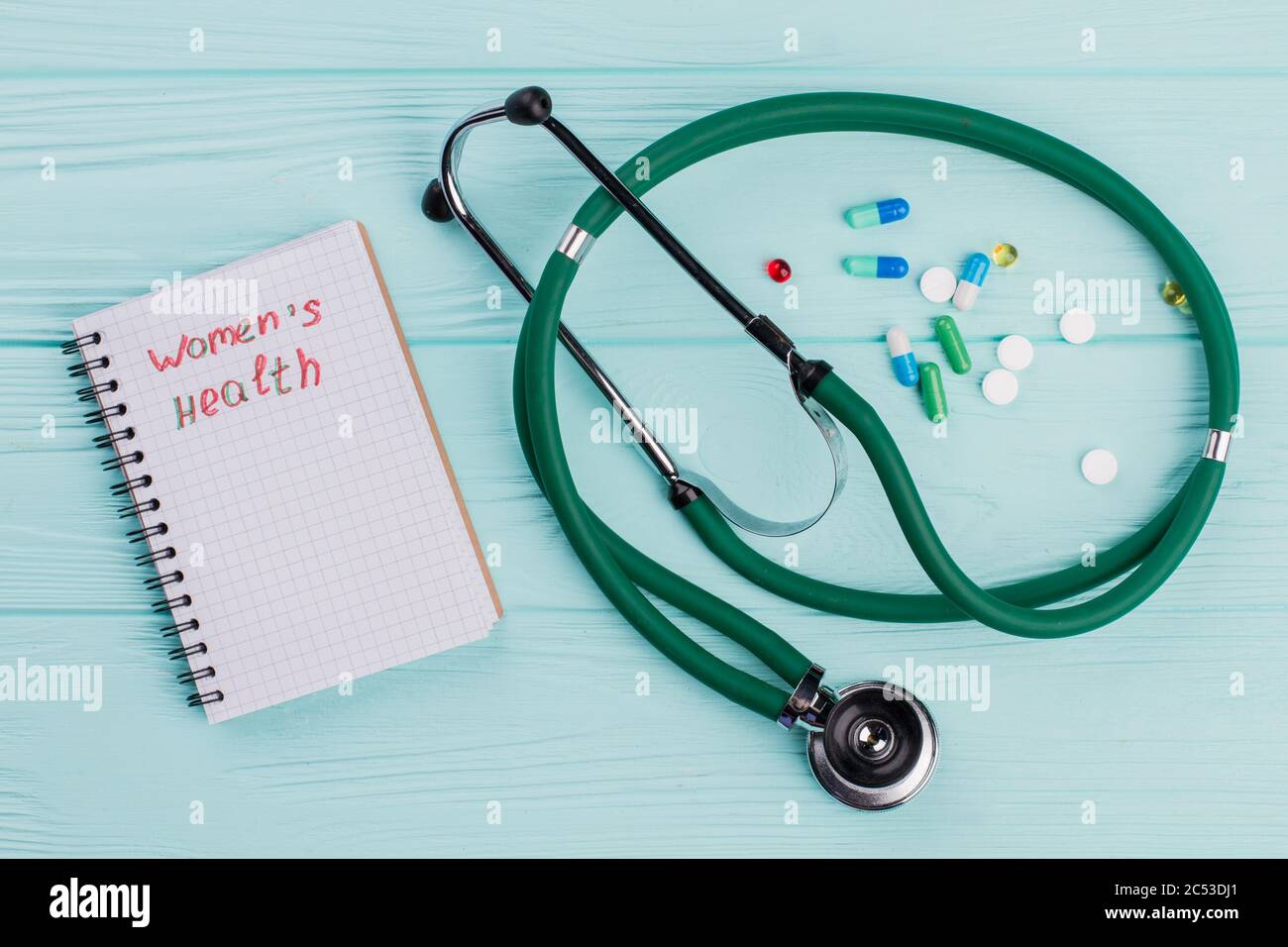 Nahaufnahme medizinisches Stethoskop und Medikamentententabletten auf blauem Hintergrund. Stockfoto