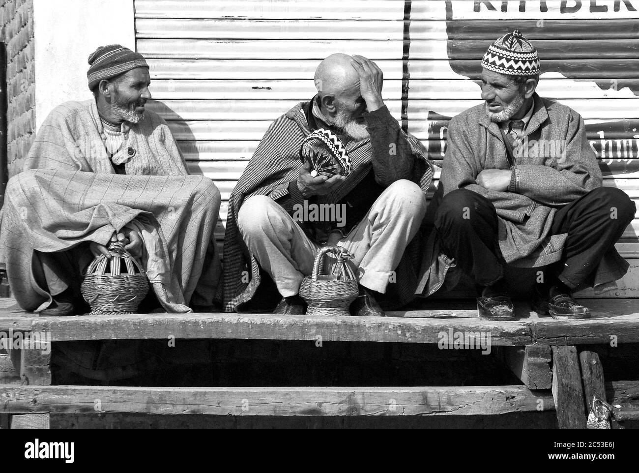 Kaschmir, Indien. Männer in Pherans, der traditionelle kashmiri Mantel, warm halten mit Feuer-Töpfe, die häufig als lokale Heizsysteme verwendet werden. März 14, 20 Stockfoto