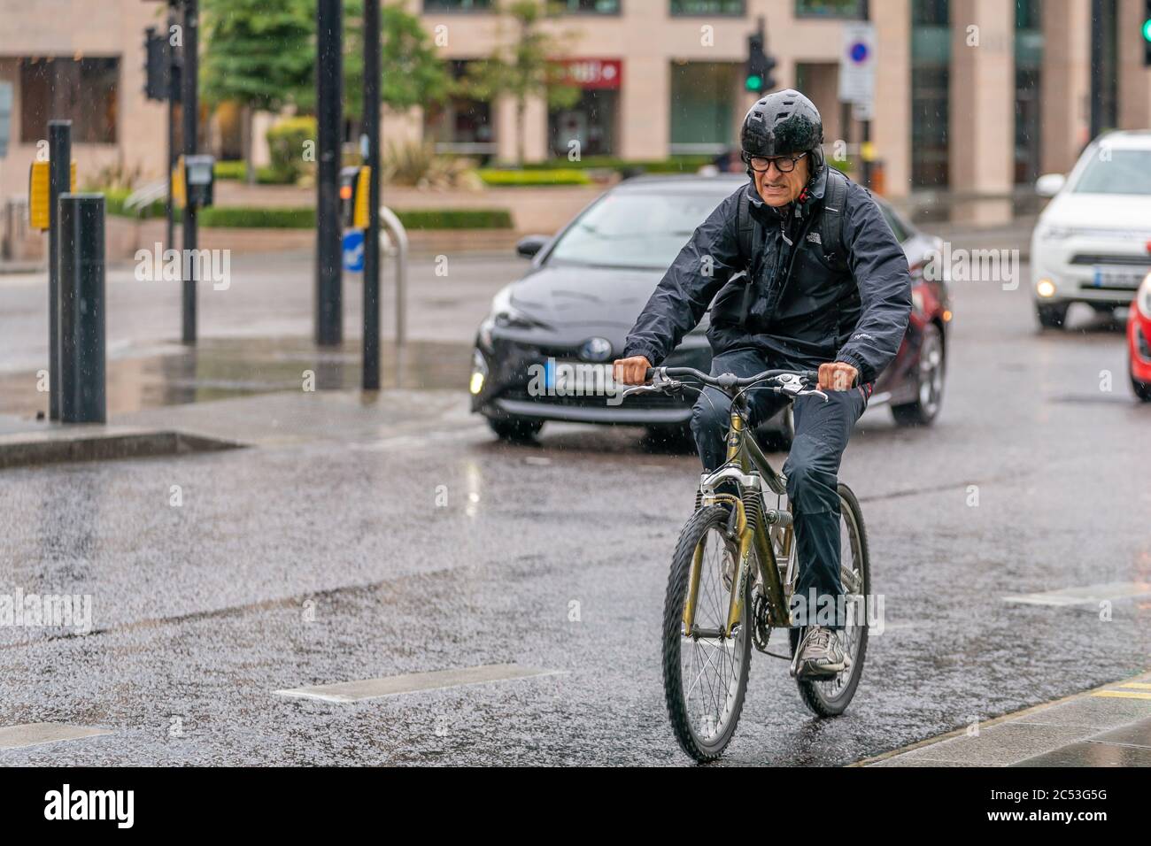 LONDON, ENGLAND - 10. JUNI 2020: Ein alter Radler, der während der COVID-19 PAN seine Macht zeigt, wurde an einem nieseligen Tag in Holborn, London, im Regen gefangen Stockfoto