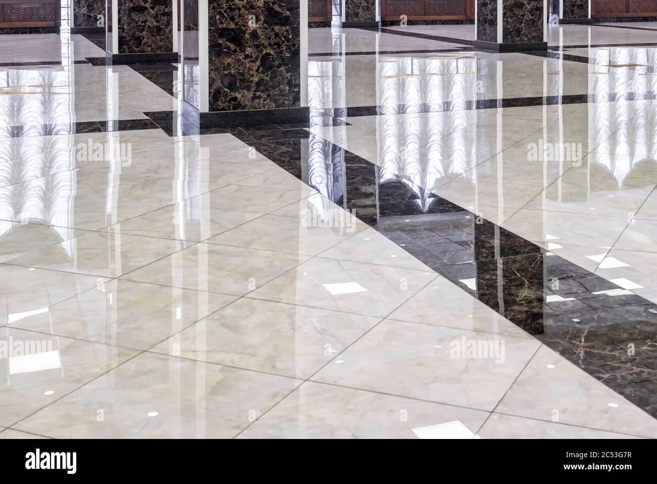 Marmorboden in der luxuriösen Lobby des Büros oder Hotels. Echte Bodenfliesen Muster mit Reflexionen für Hintergrund. Glänzender Boden nach professioneller Reinigung. Stockfoto