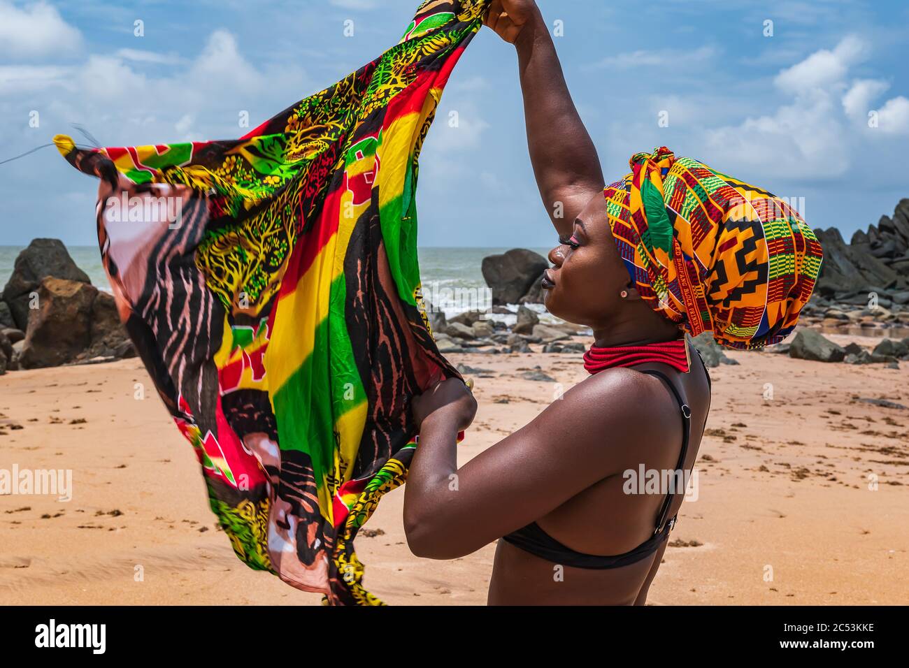 Ghana Frau am schönen Strand von Axim, in Ghana Westafrika gelegen. Kopfschmuck in traditionellen Farben aus Afrika. Stockfoto