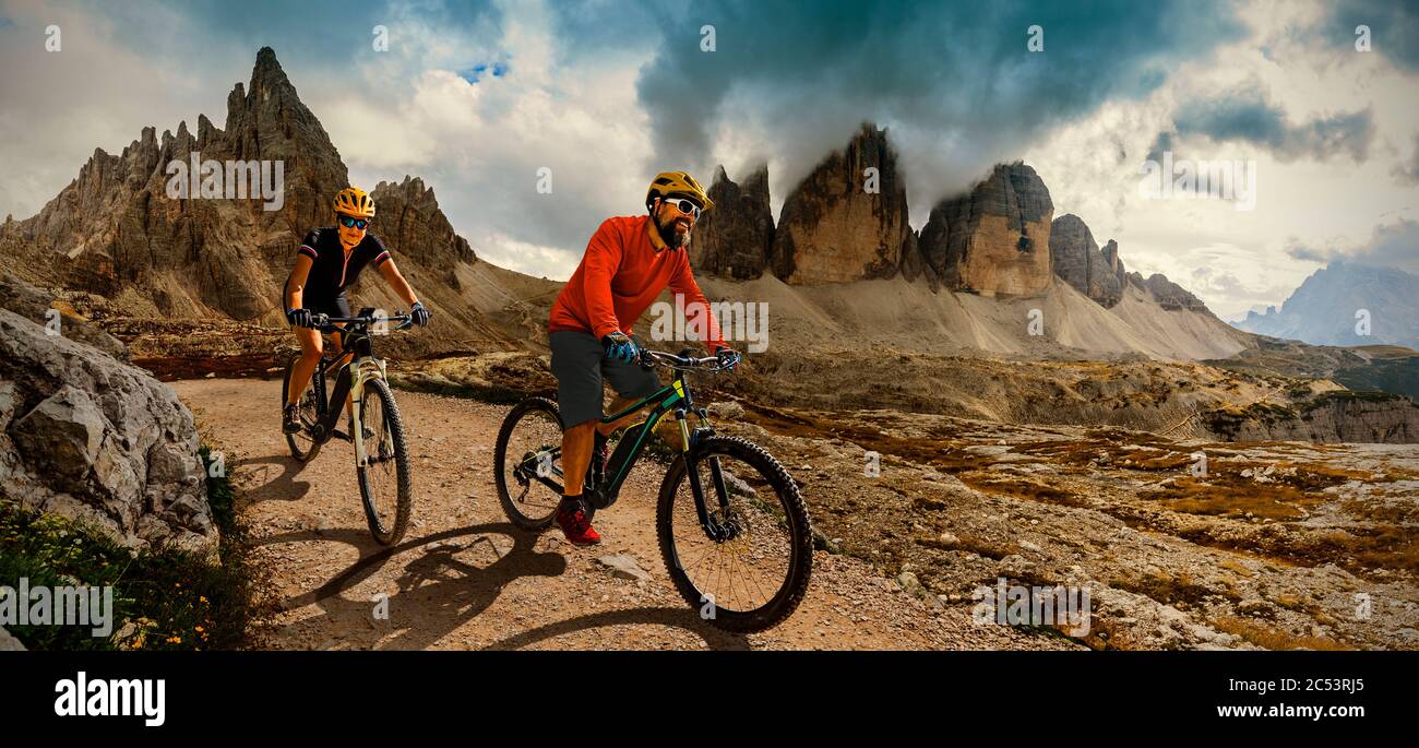 Paar Radfahren auf Elektro-Fahrrad, Fahrten Bergweg. Frau und Mann fahren auf dem Fahrrad in der Dolomitenlandschaft. Radfahren e-mtb Enduro Trac Stockfoto