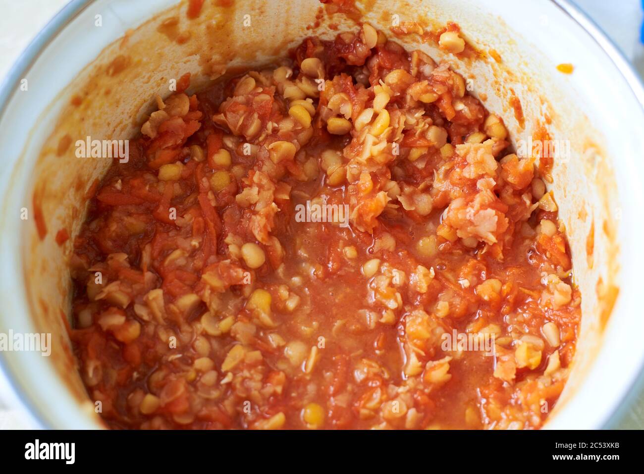 Gekochte Erbsen mit Karotten, Zwiebeln und Tomatenmark in einer Pfanne, Nahaufnahme Stockfoto
