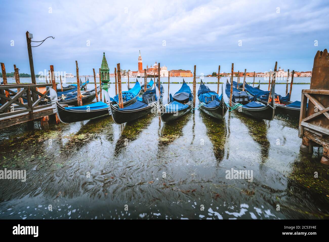 Malerische Aussicht auf Gondeln im Canale Grande in warmen Licht am Abend, Kirche San Giorgio Maggiore im Hintergrund. Stockfoto Malerische Aussicht auf Gondeln im Canale Grande in warmen Licht am Abend, Kirche San Giorgio Maggiore im Hintergrund. Stockfoto