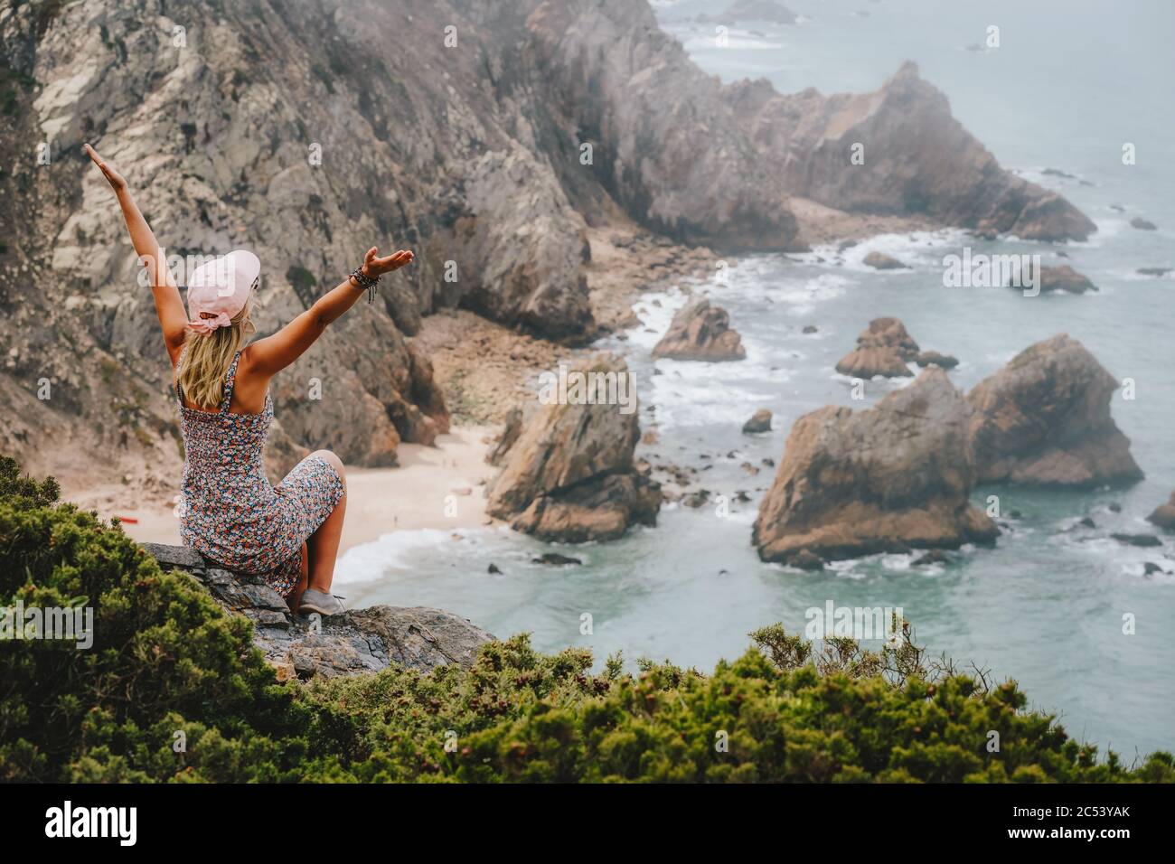 Glückliche Touristen Frauen genießen epischen Strand Praia da Ursa am Morgen. Surreale Landschaft von Sintra, Portugal. Küstenlandschaft des Atlantischen Ozeans. Stockfoto