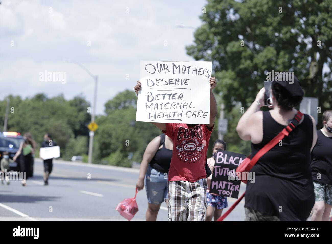Menschen marschieren und halten Plakate entlang der Straßen, um Anti-Rassismus und Black Lives Matter zu unterstützen Stockfoto