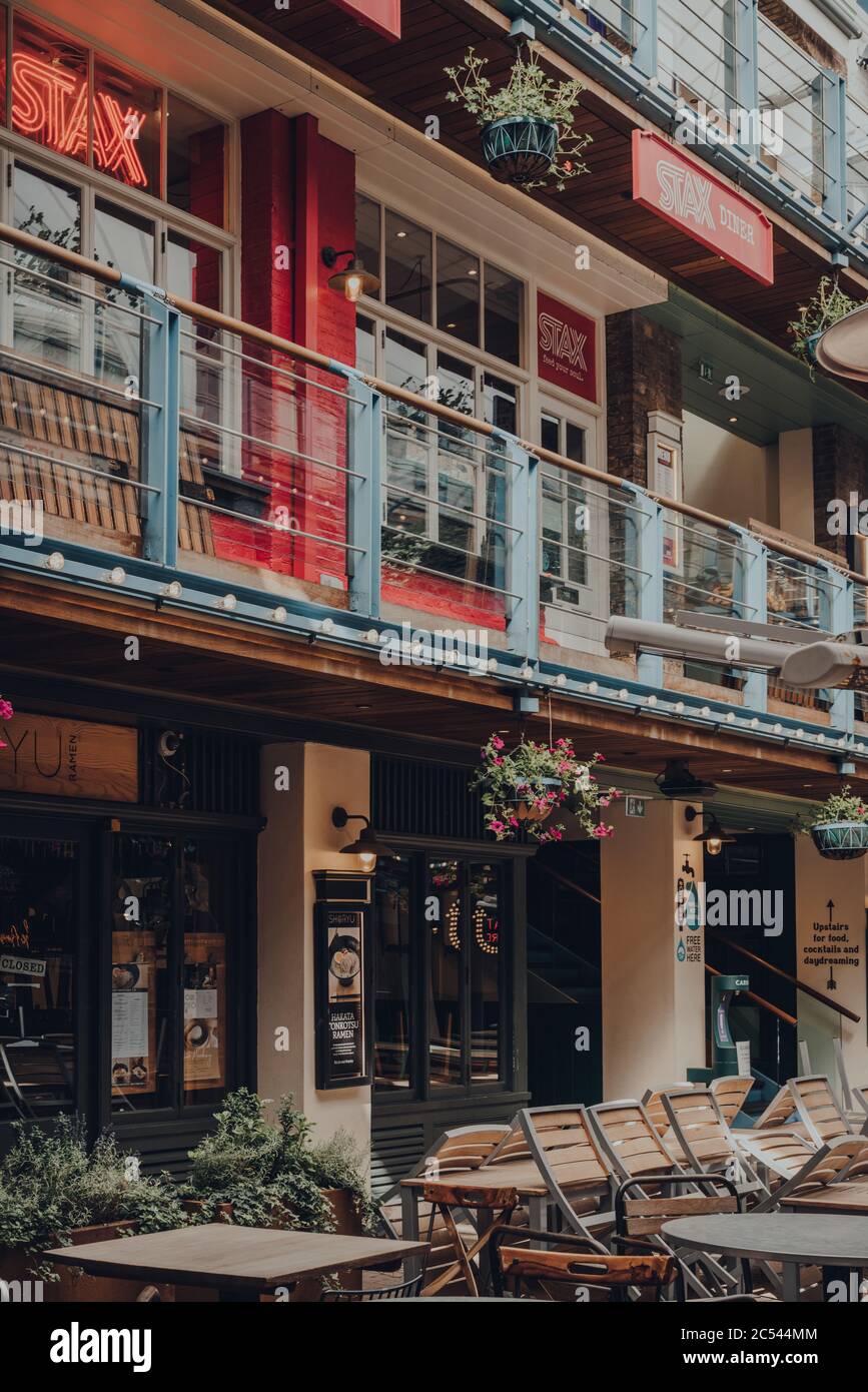 London, Großbritannien - 13. Juni 2020: Leere Tische im Königly Court, einem dreistöckigen Restaurant- und Restauranthof im Freien im Herzen des Londoner West End. Auswahl Stockfoto