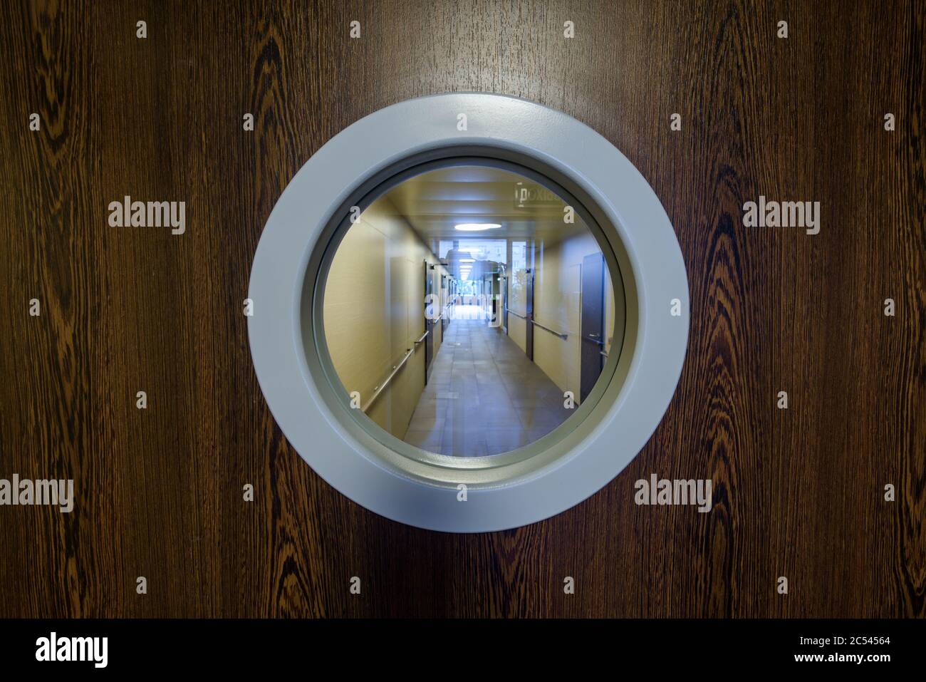 Eingang zum Krankenhausflur mit dem runden Fenster. Die Holztür in der Klinik. Stockfoto
