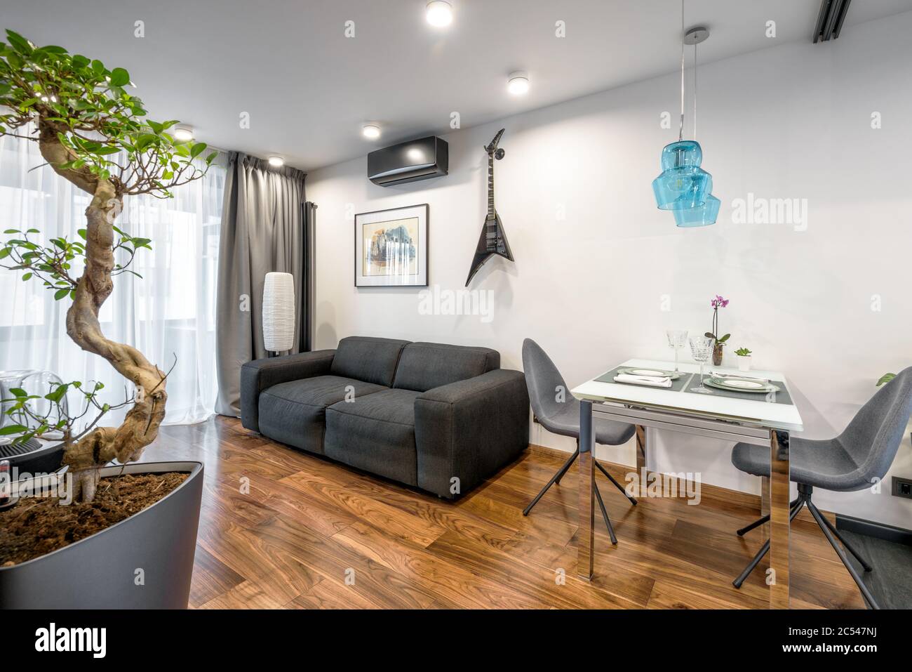 Moskau - 25. März 2018: Moderne Wohneinrichtung mit Couch, Tisch und Pflanzen. Schöne minimalistische Inneneinrichtung des Wohnzimmers mit weißen Wänden. Luxus Stockfoto
