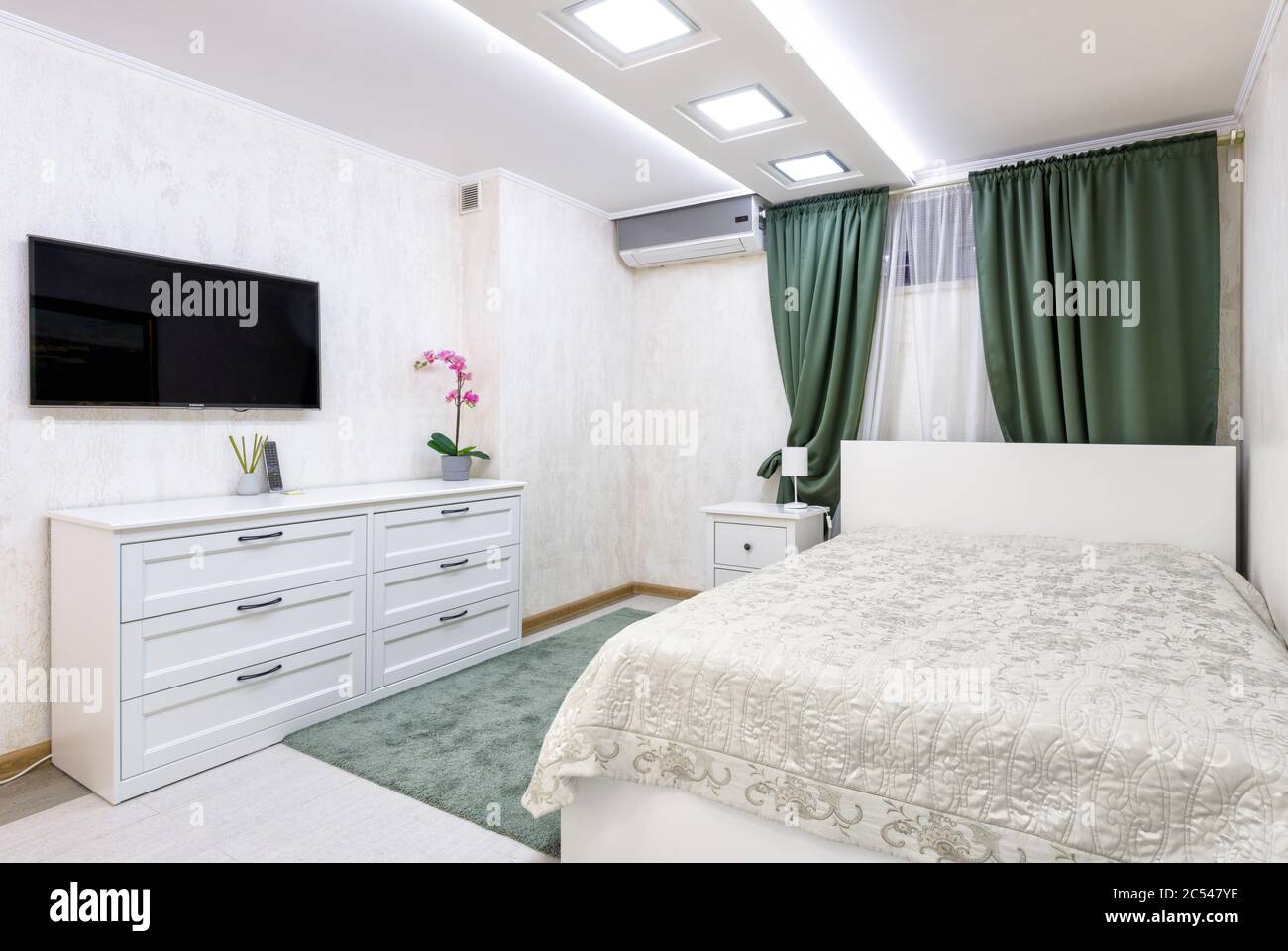 Moskau - Aug 24, 2019: Schlichtes gemütliches Schlafzimmer-Interieur mit weißem Design. Moderne Einrichtung des Hotels oder Hauses mit Bett und Kommode. Modernes sma Stockfoto