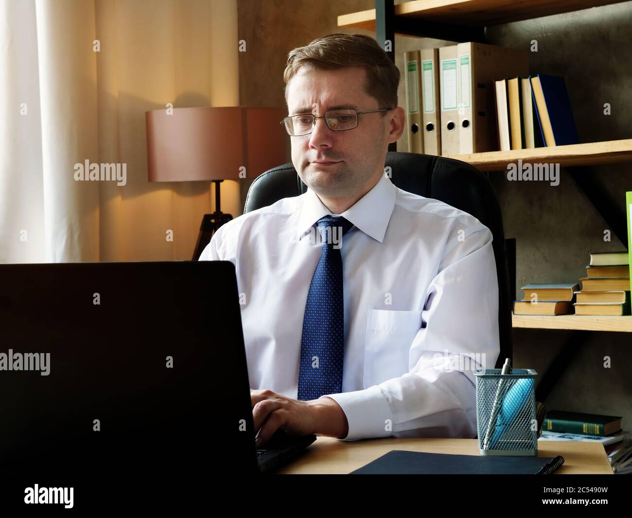 Junge seriöse Manager arbeitet im Büro mit einem Computer. Stockfoto