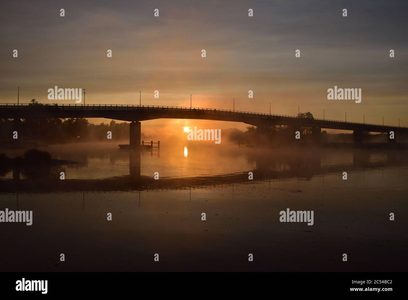 Sonnenaufgang, der Umriss der Brücke im Nebel, ein geheimnisvoller Blick. Nebel. Stockfoto