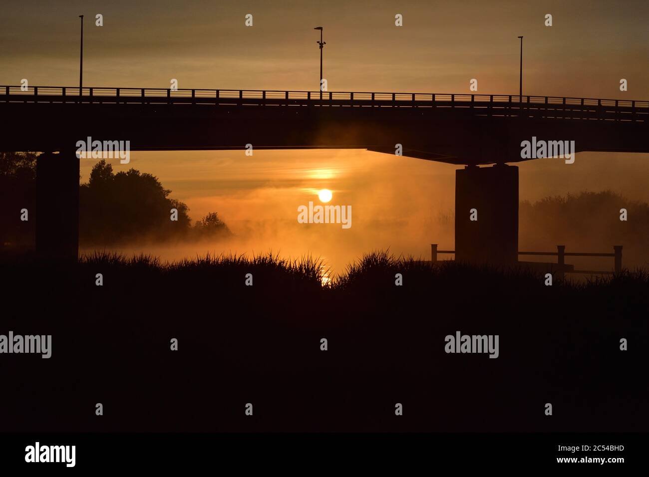 Sonnenaufgang, der Umriss der Brücke im Nebel, ein geheimnisvoller Blick. Nebel. Stockfoto