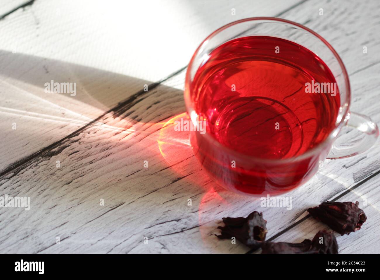 Roter Hibiskustee in einem Glas Becher auf einem Holzhintergrund. Karkade mit rotem Tee. Gesunder Tee. Stockfoto