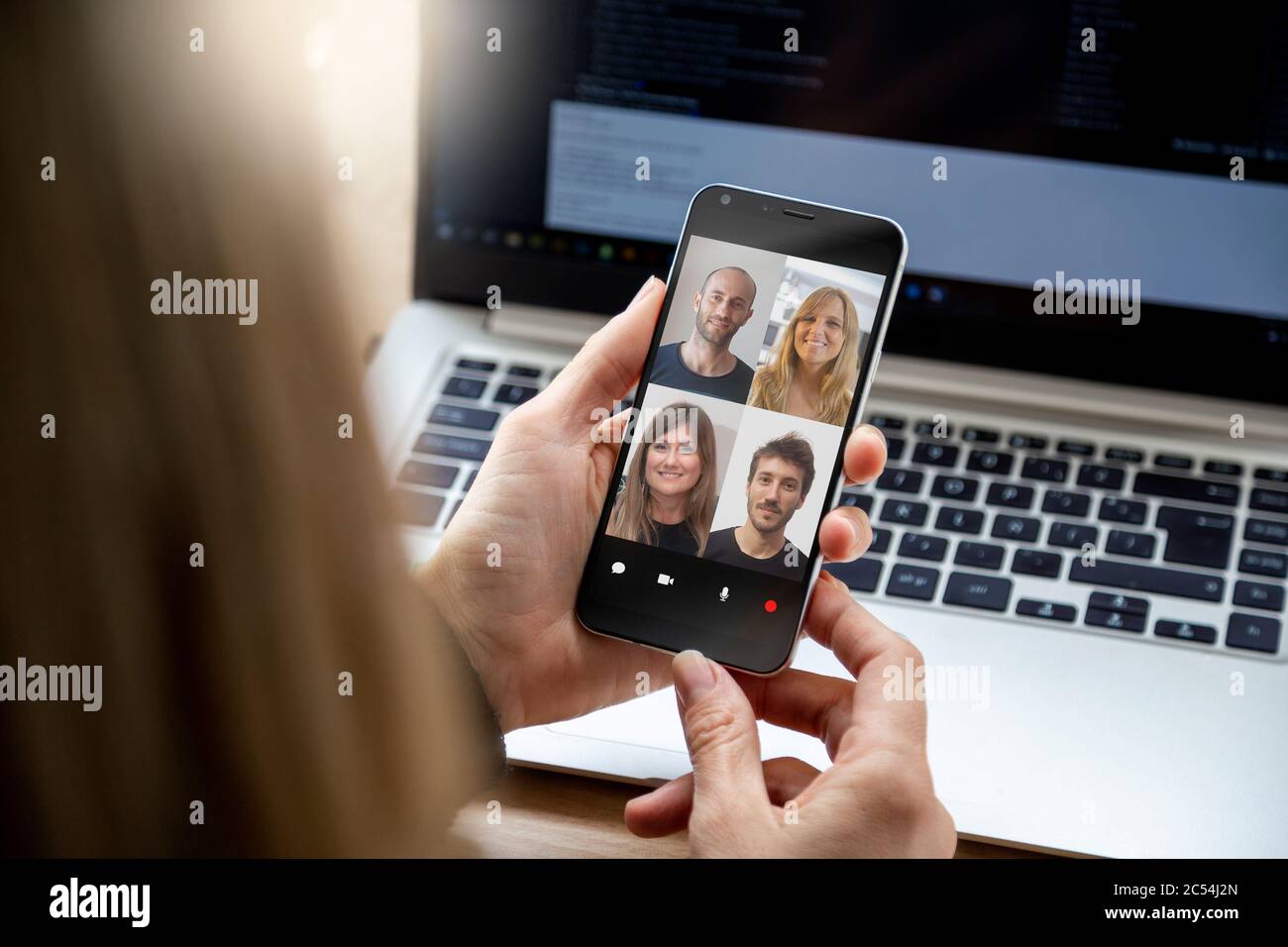 Videokonferenz mit einer Gruppe von Menschen. Junge Geschäftsfrau, die einen Video-Chat mit Kollegen auf ihrem Mobiltelefon hat. Stockfoto