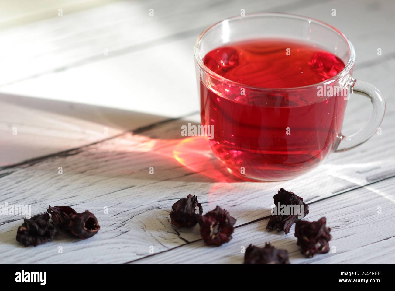 Roter Hibiskustee in einem Glas Becher auf einem Holzhintergrund. Karkade mit rotem Tee. Gesunder Tee. Stockfoto
