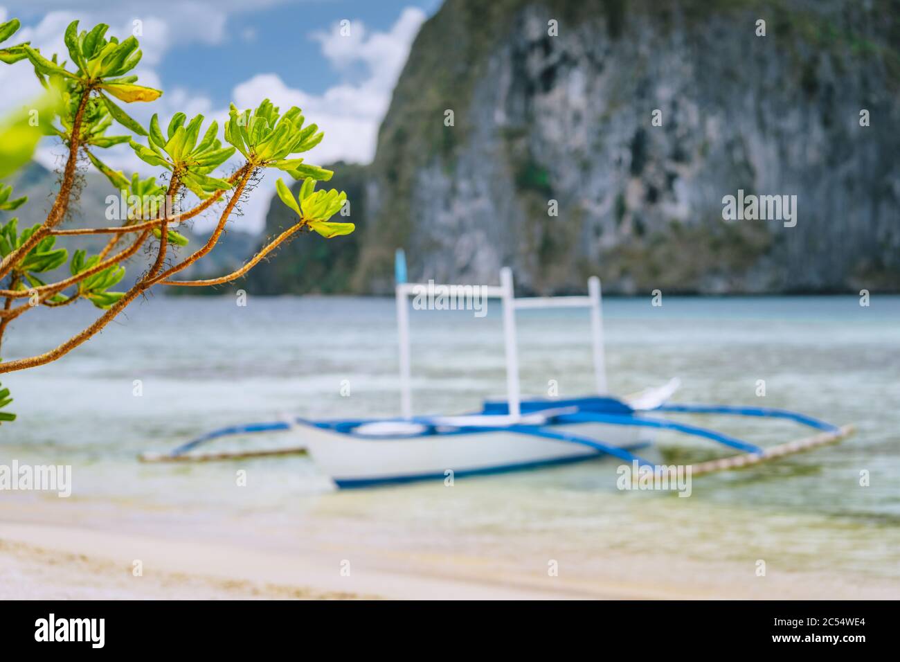 El Nido. Entschärft traditionelles filippino-boot an Land mit Pinagbuyutan-Insel im Hintergrund. Palawan, Bacuit Archipel, Philippinen. Stockfoto