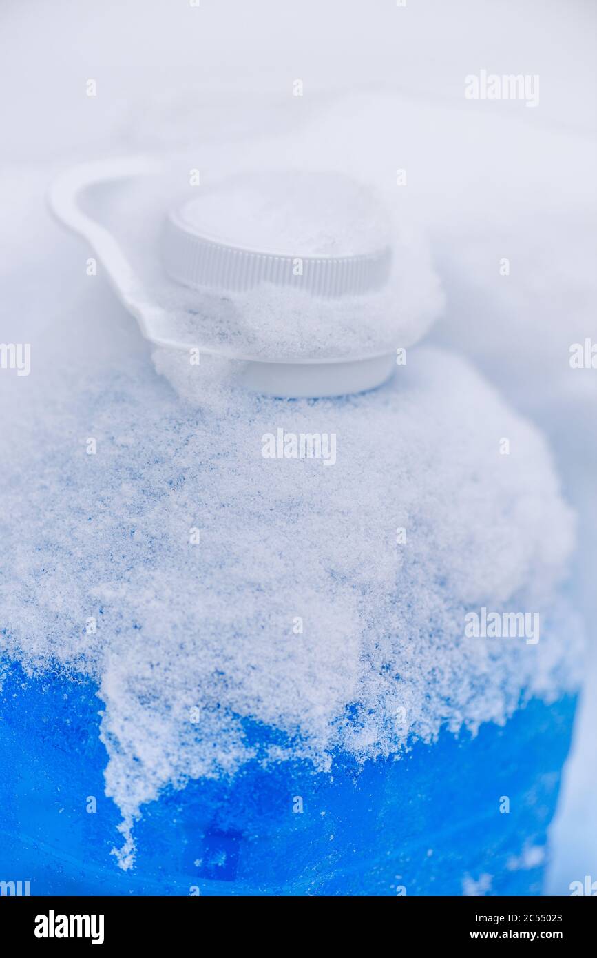 Auto nicht-gefrierende Flüssigkeit in Frost auf Schnee. Blaue Flüssigkeit im Frost während des Tages. Nicht-gefrierende Flüssigkeit zum Waschen von Autoglas im Winter. Winter Auto Waschglas l Stockfoto