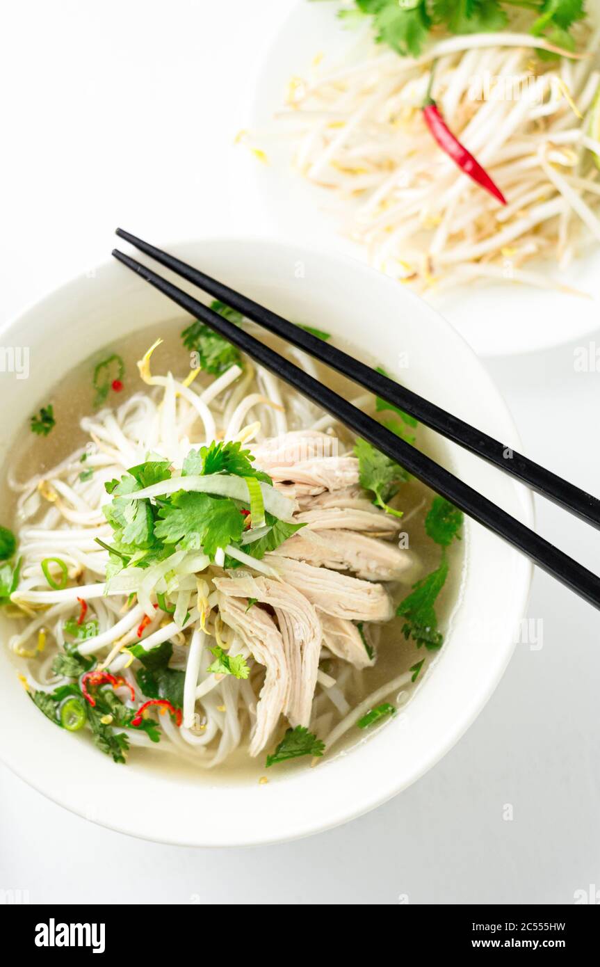 Vietnamesische Pho-Suppe von oben. Diese Pho-Suppe ist ein klassisches, authentisches vietnamesisches Essen und wird in einer weißen Schüssel mit Hühnerbrühe und viel f serviert Stockfoto