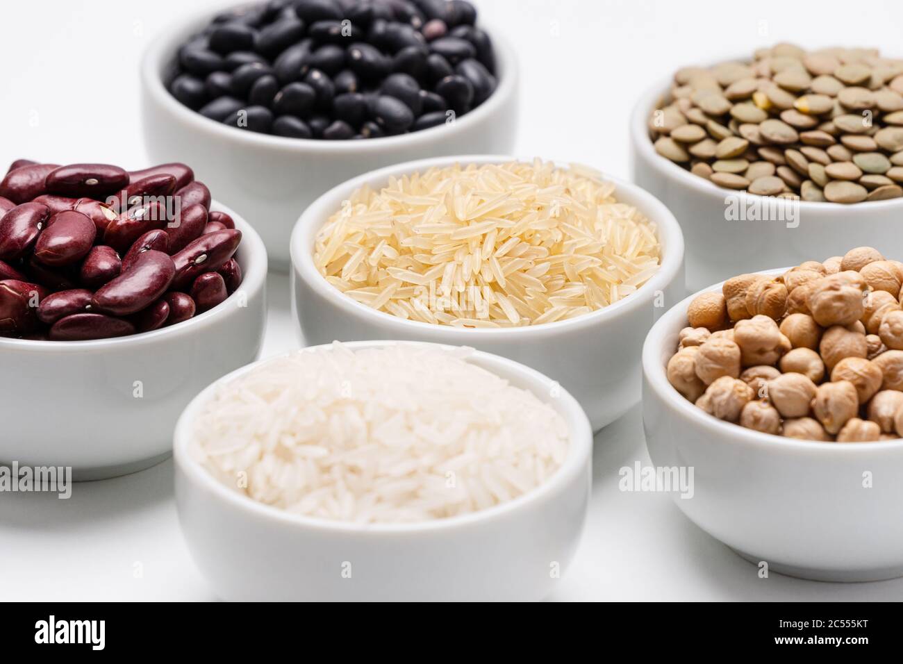 Schalen von gemischten Hülsen und Körnern. Schüssel mit Basmati-Reis umgeben von anderen Sorten von Getreide und Hülsenfrüchten, wie: Kichererbsen, rote Kidney Beans, gre Stockfoto