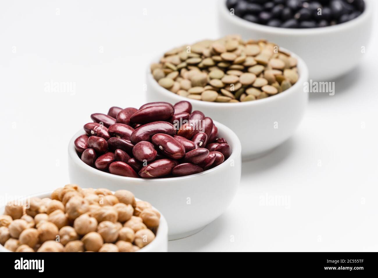 Rote Bohnen und verschwommene Hülsenfrüchte. 4 Sorten von Hülsenfrüchten (trockene essbare Samen von Pflanzen), der Fokus liegt auf den roten Kidney-Bohnen, während die anderen Hülsenfrüchte Stockfoto