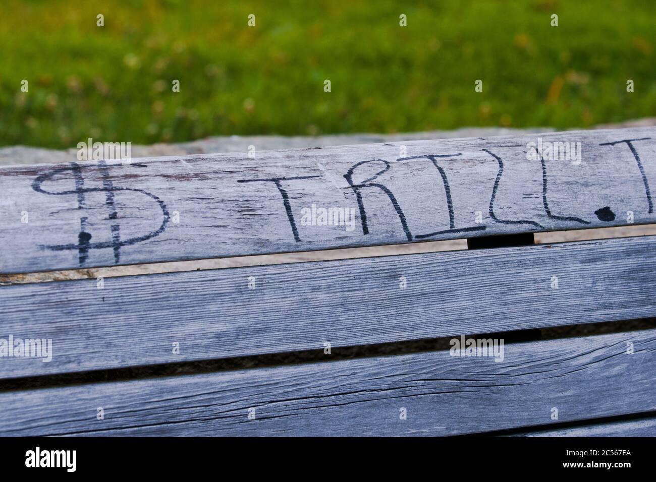 Trill und Geld Zeichen Graffiti auf Park Bank Stockfoto