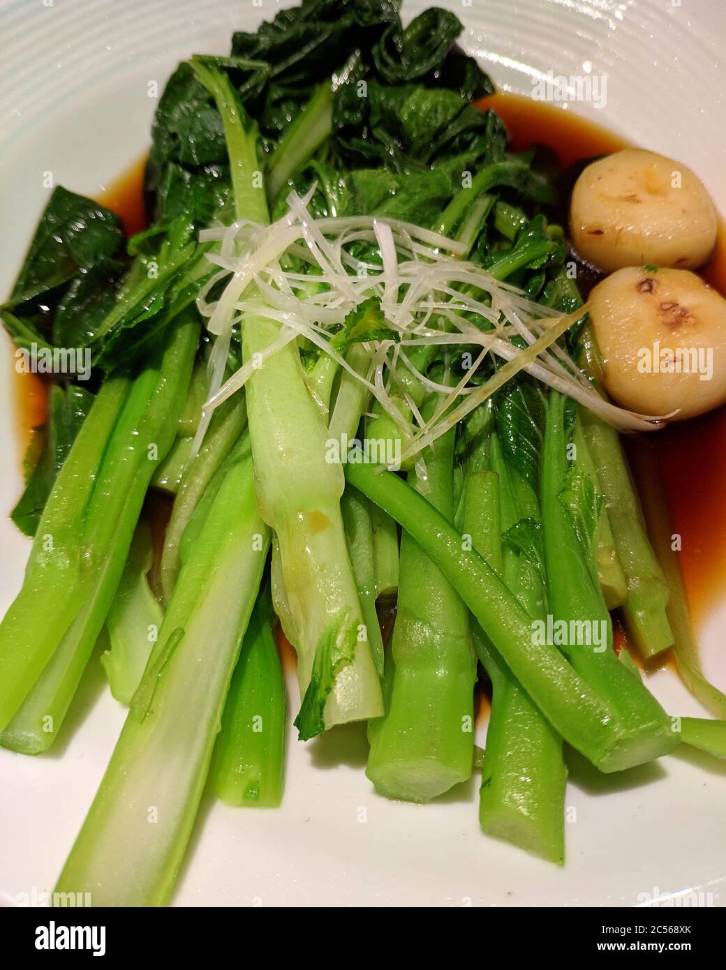 Grünes Gemüse mit Sojasauce in den Teller mit zwei Chufa kochen Stockfoto