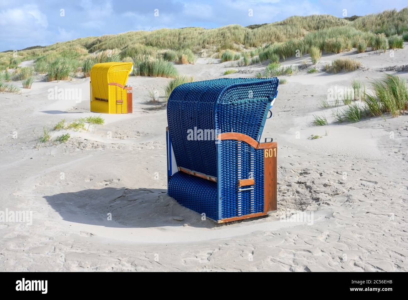 Deutschland, Niedersachsen, Ostfriesland, Juist, Strandliegen isoliert am Rande der Dünen. Stockfoto