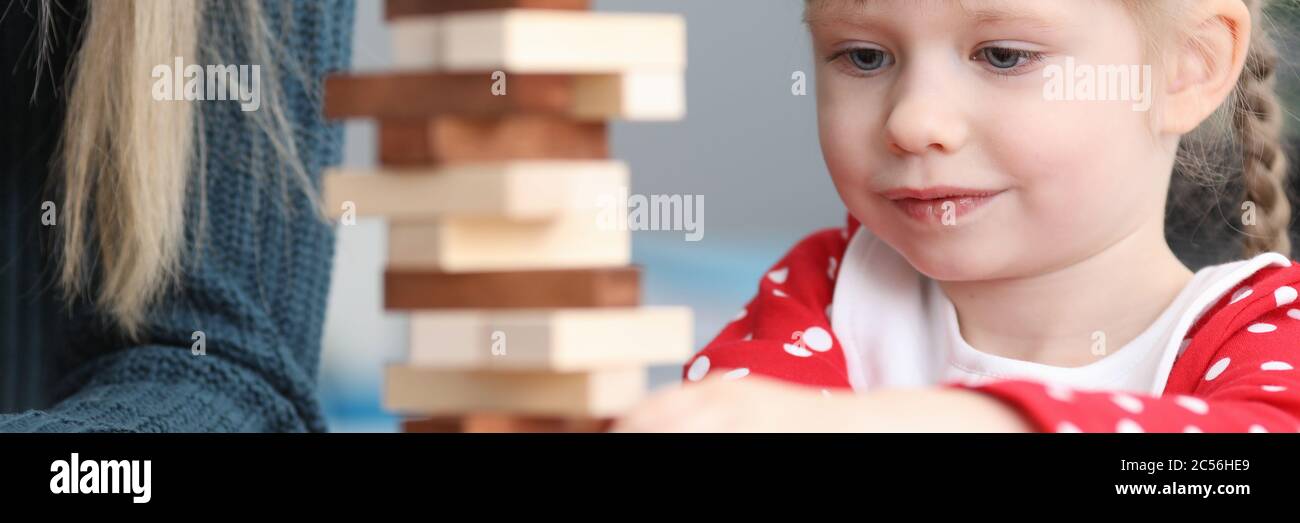 Mädchen ziehen Holzdetails aus dem konstruierten Turm heraus Stockfoto