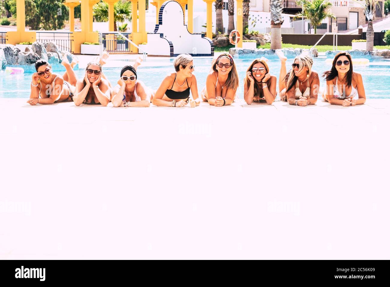 Sommerferienurlaub für kaukasische Frauen Freunde - Gruppe junger Frauen legen sich am Pool nieder, genießen die heiße Jahreszeit zusammen in Freundschaft - Hap Stockfoto