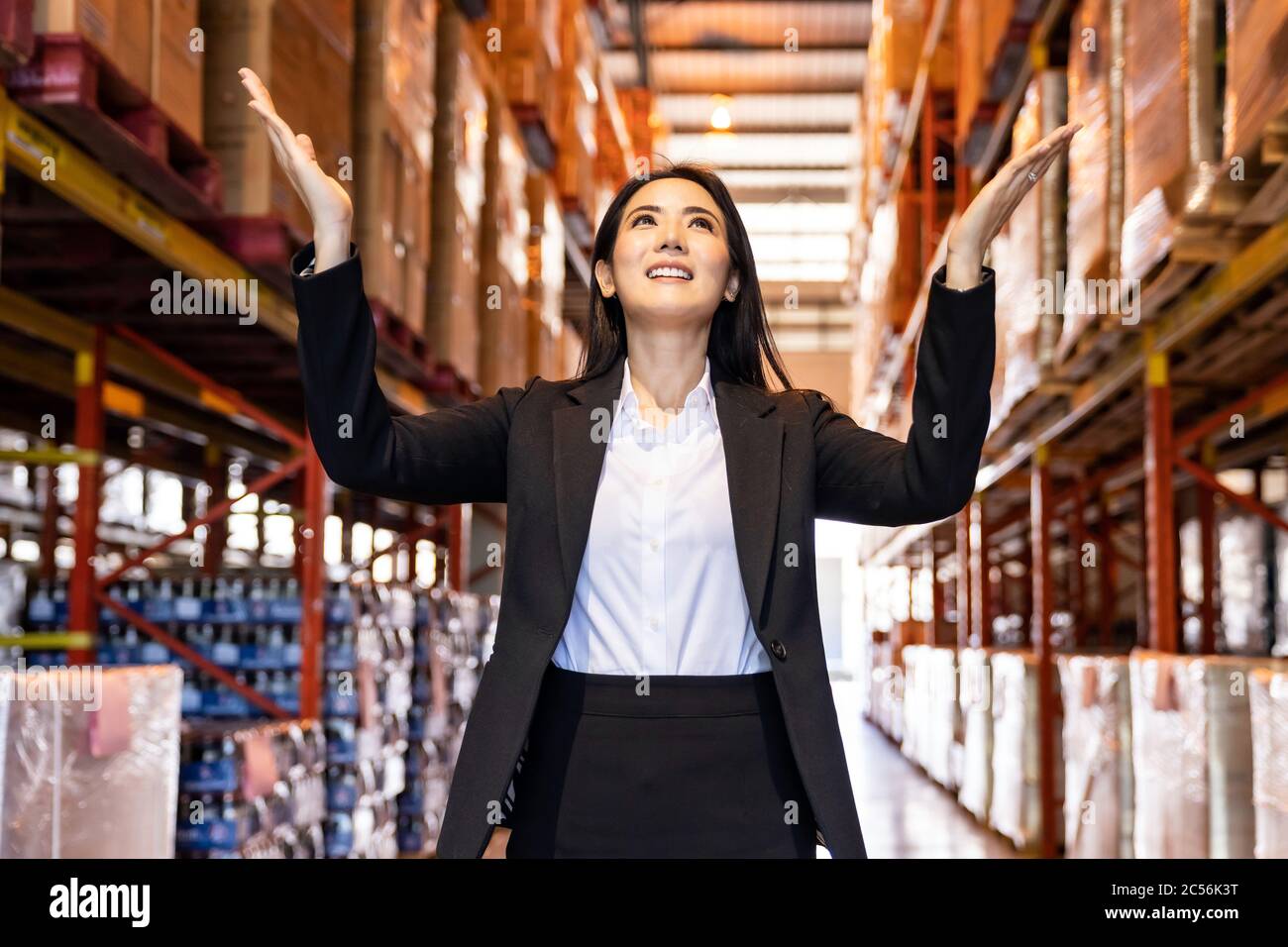 Porträt der asiatischen Vertrauen Geschäftsfrau stehend in großen Fabrik und Distributionslager Umgebung. Unternehmer und Investitionskonzept. Stockfoto