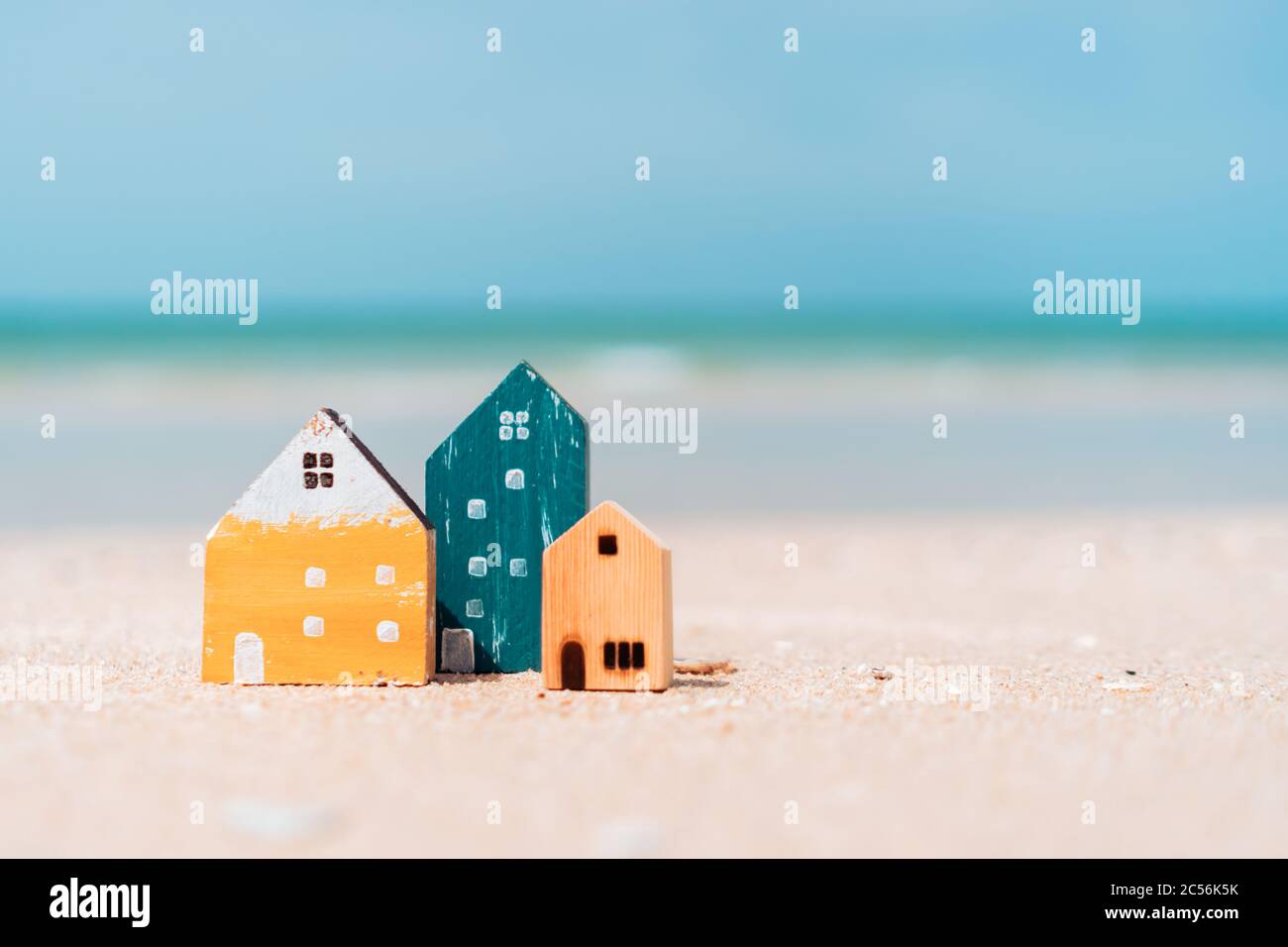 Modell eines kleinen Hauses auf Sand mit Natur Strand Hintergrund. Traum-Leben-Konzept. Stockfoto