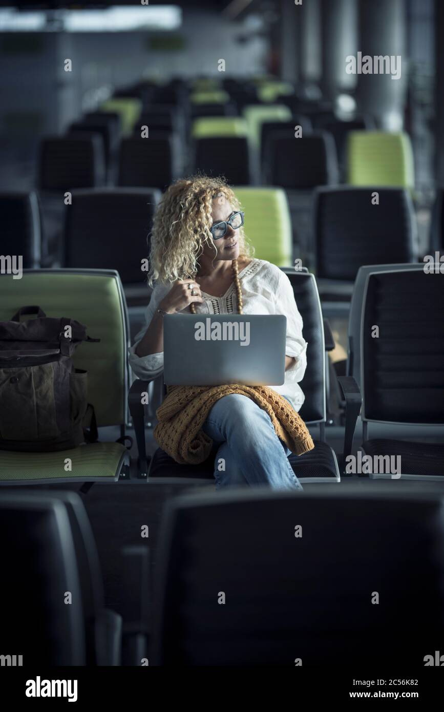 Travel People Konzept mit einsamen modernen schöne Frau sitzen auf Sitze am Flughafen oder Bahnhof warten auf den Start und genießen Sie die Reise - Verzögerung oder Stornierung Stockfoto