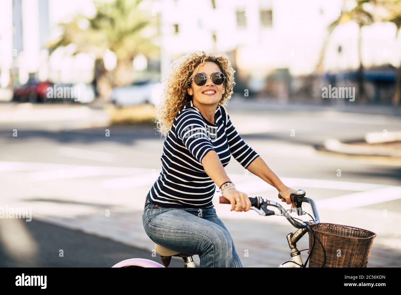 Schöne und fröhliche Erwachsene junge Frau genießen Fahrradfahren in sonnigen städtischen Freizeitangeboten im Freien in der Stadt - fröhliches Menschenporträt - trendige weibliche Person o Stockfoto