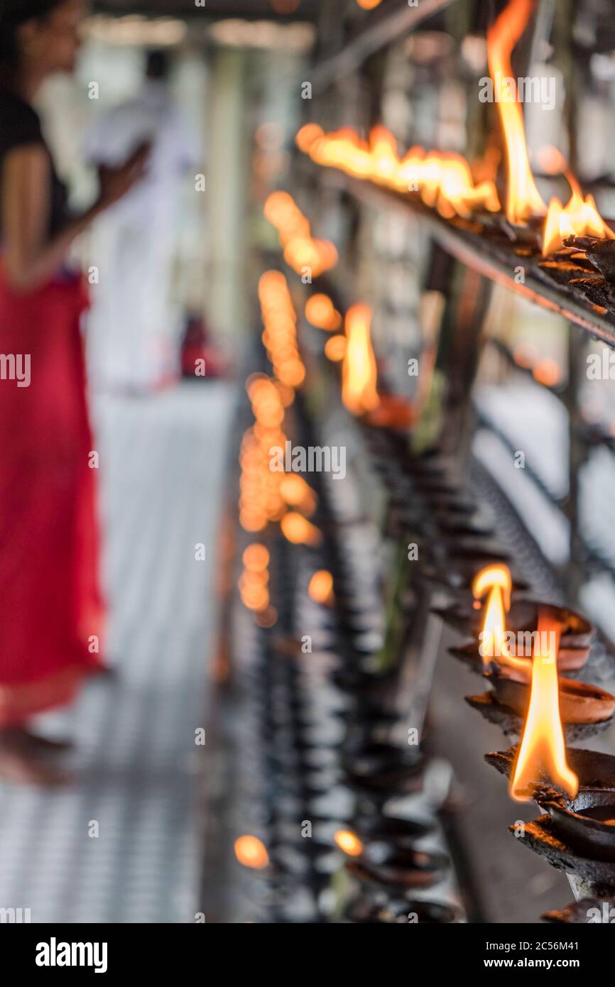 Ritualöl-Lampe aus Ton mit einem Gläubigen, der in Sri Lanka betet Stockfoto