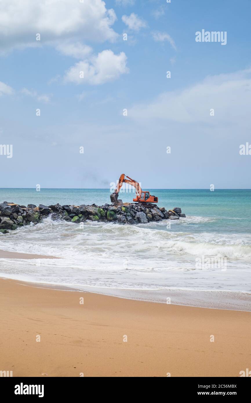 Bagger auf einem Felsbrecher an der Küste von Sri Lanka Stockfoto