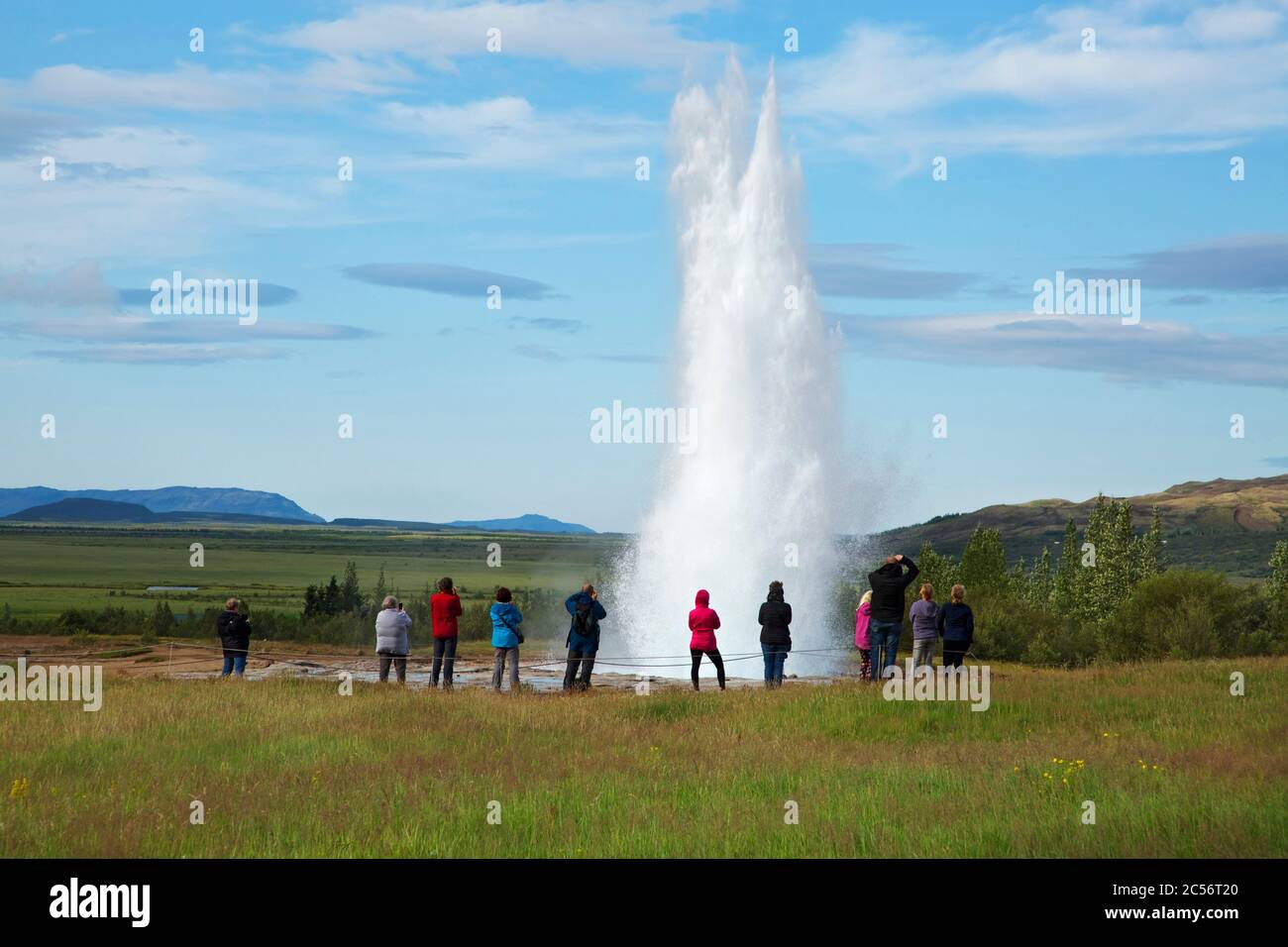 Touristen staunen über einen Ausbruch des Strokkur-Geysir bei Haukadalur Stockfoto