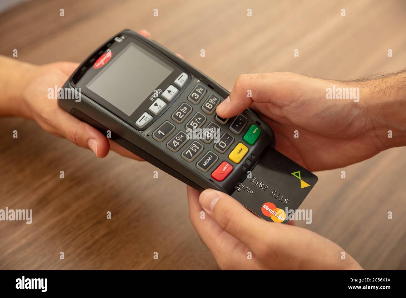 Athen, Griechenland. Juni 27, 2020. Wireless POS Zahlungsterminal Ingenico mit Kreditkarte Mastercard isoliert auf weißem Hintergrund, Nahaufnahme. Stockfoto